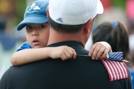 immigrant child held by father during a rally